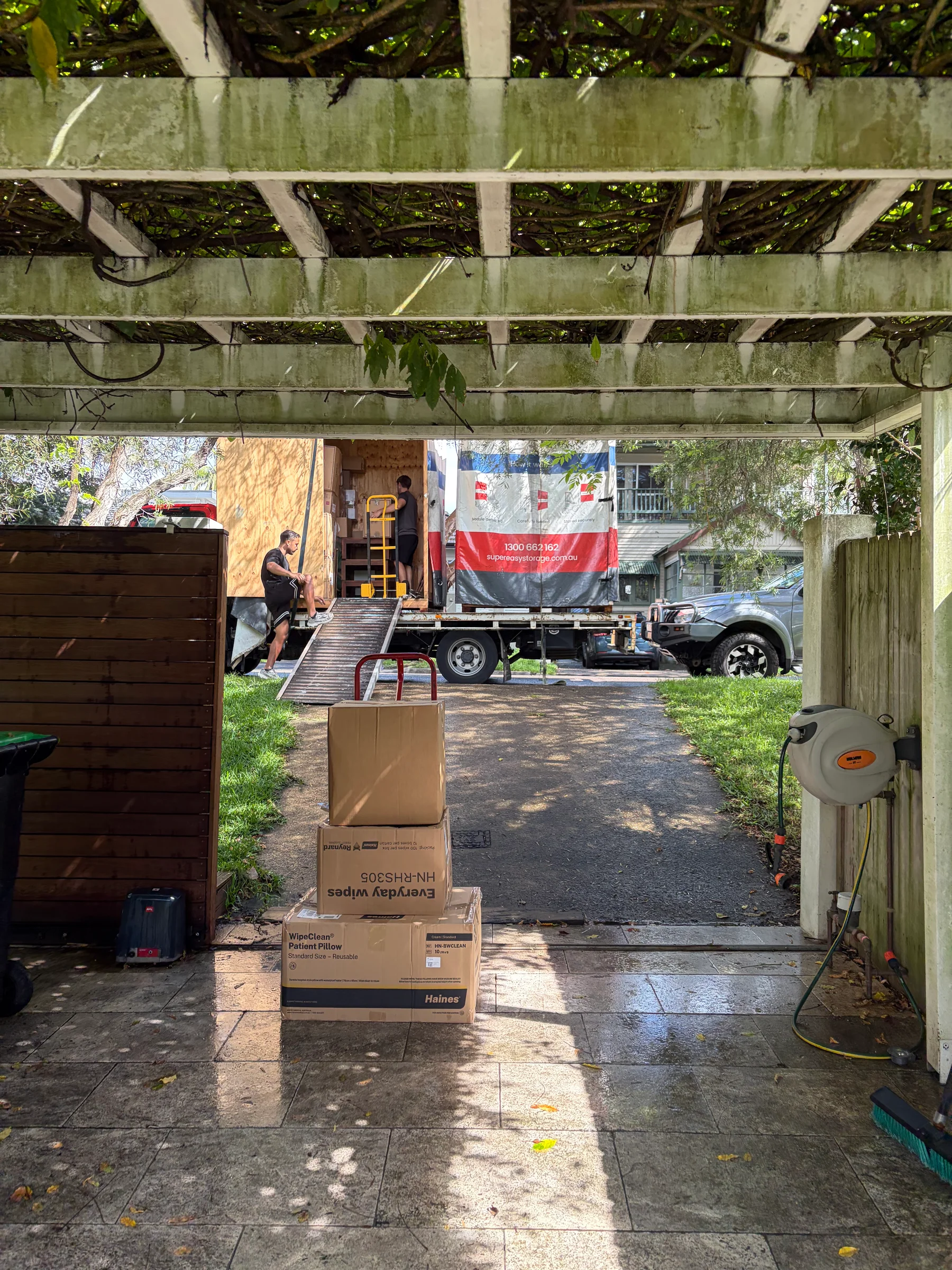 A moving truck unloading boxes in the Freshwater driveway.