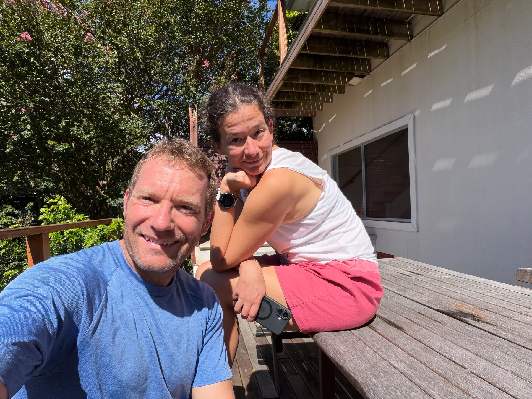 Matt and Steph sitting together on a sunlit deck after the move.
