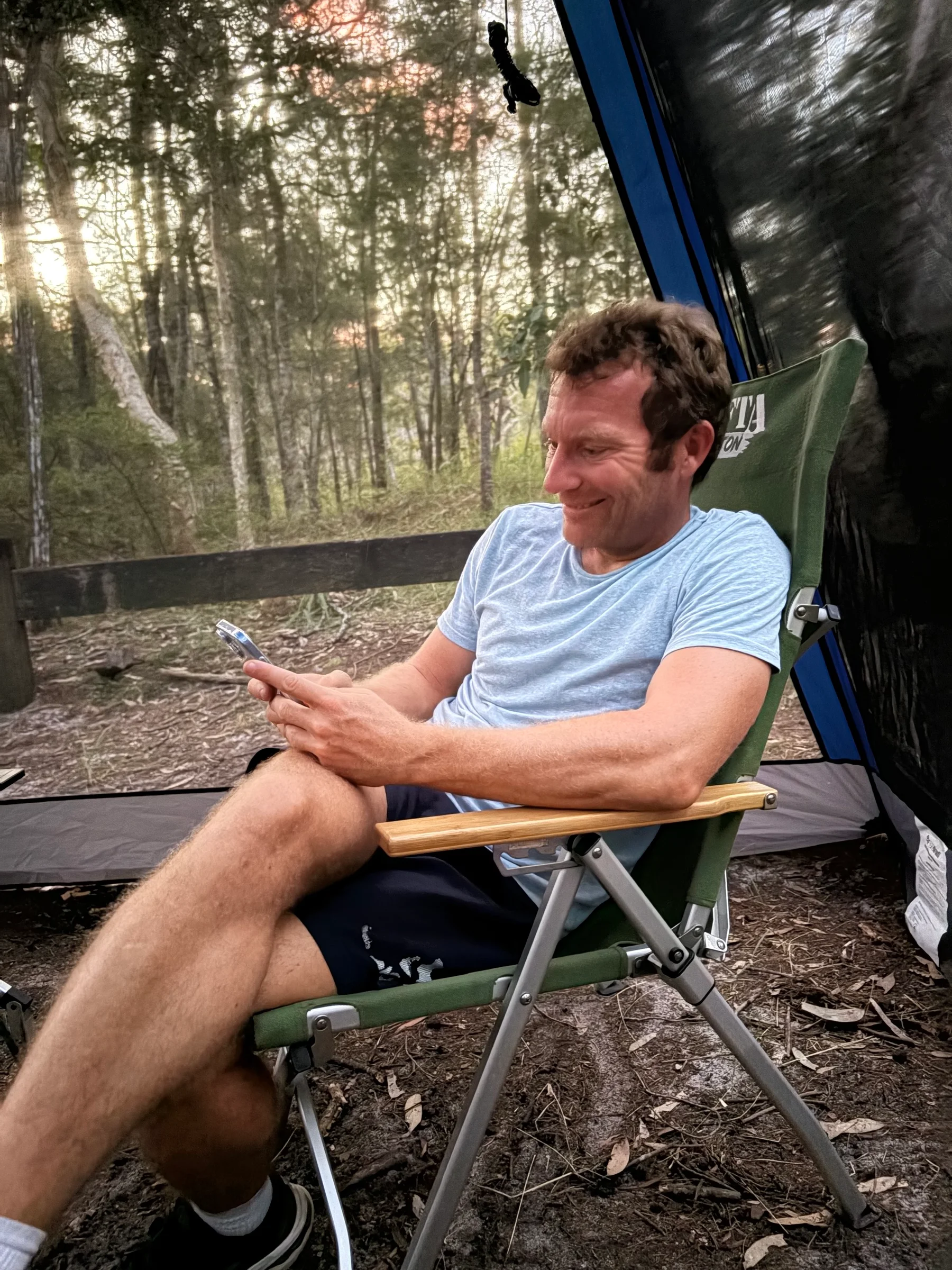 A camping chair set up in the shade near the river at Harry's Hut campground.