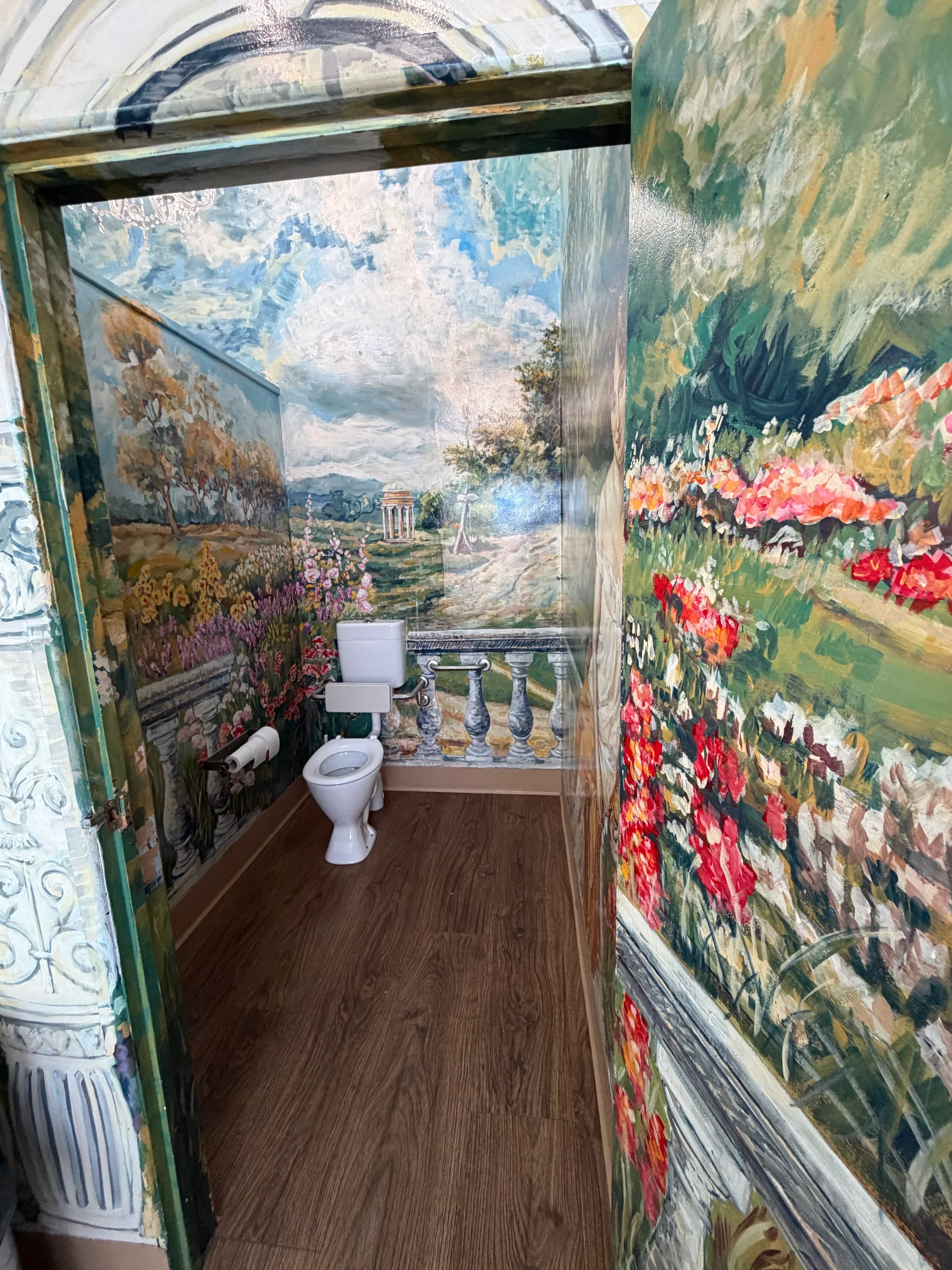 A vivid interior with every surface painted in bold, bright colours — walls, ceiling and floor covered in layered decorative patterns.