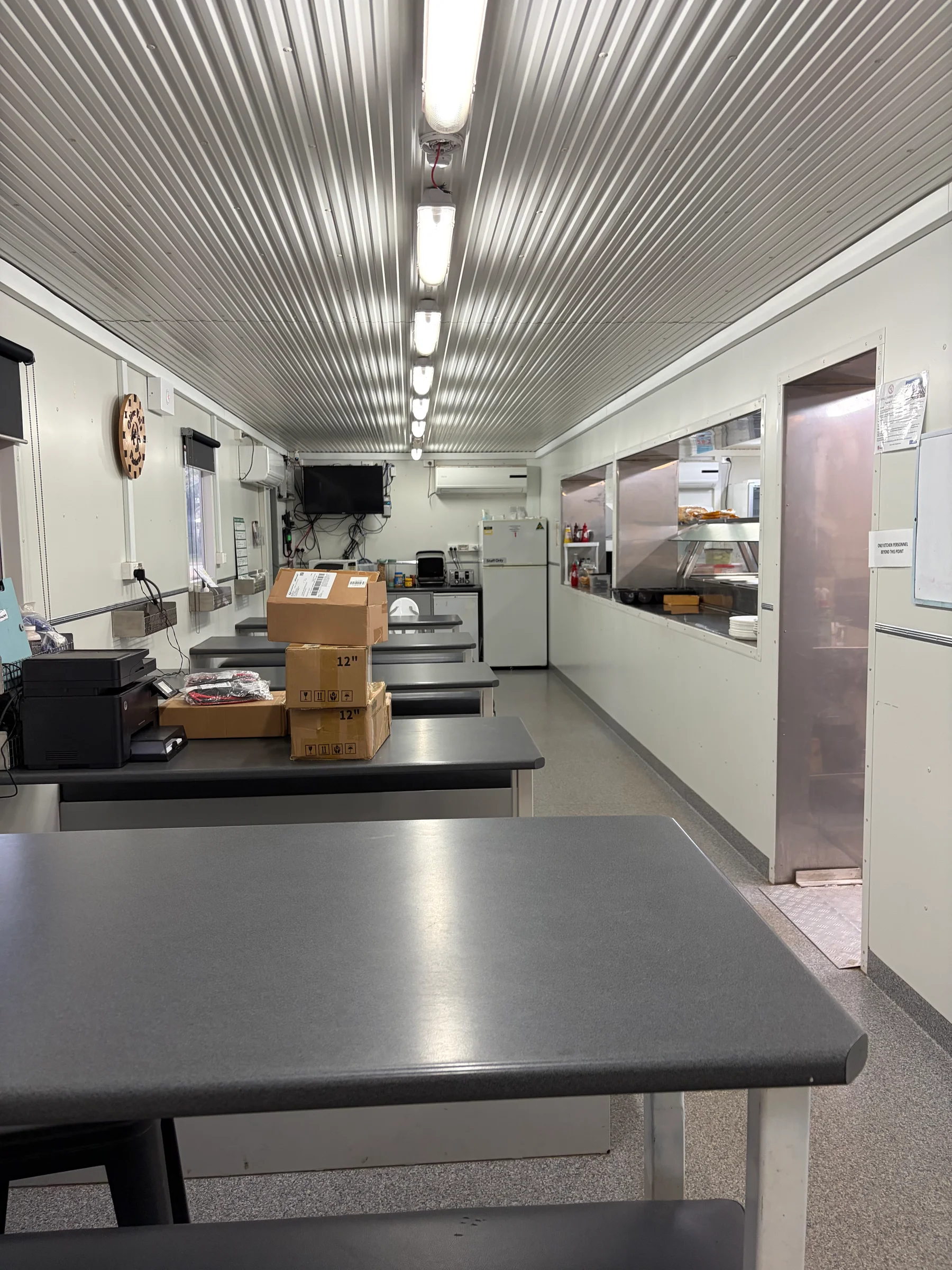 Interior of the station's buffet dining area with long stainless steel countertops and commercial refrigerators