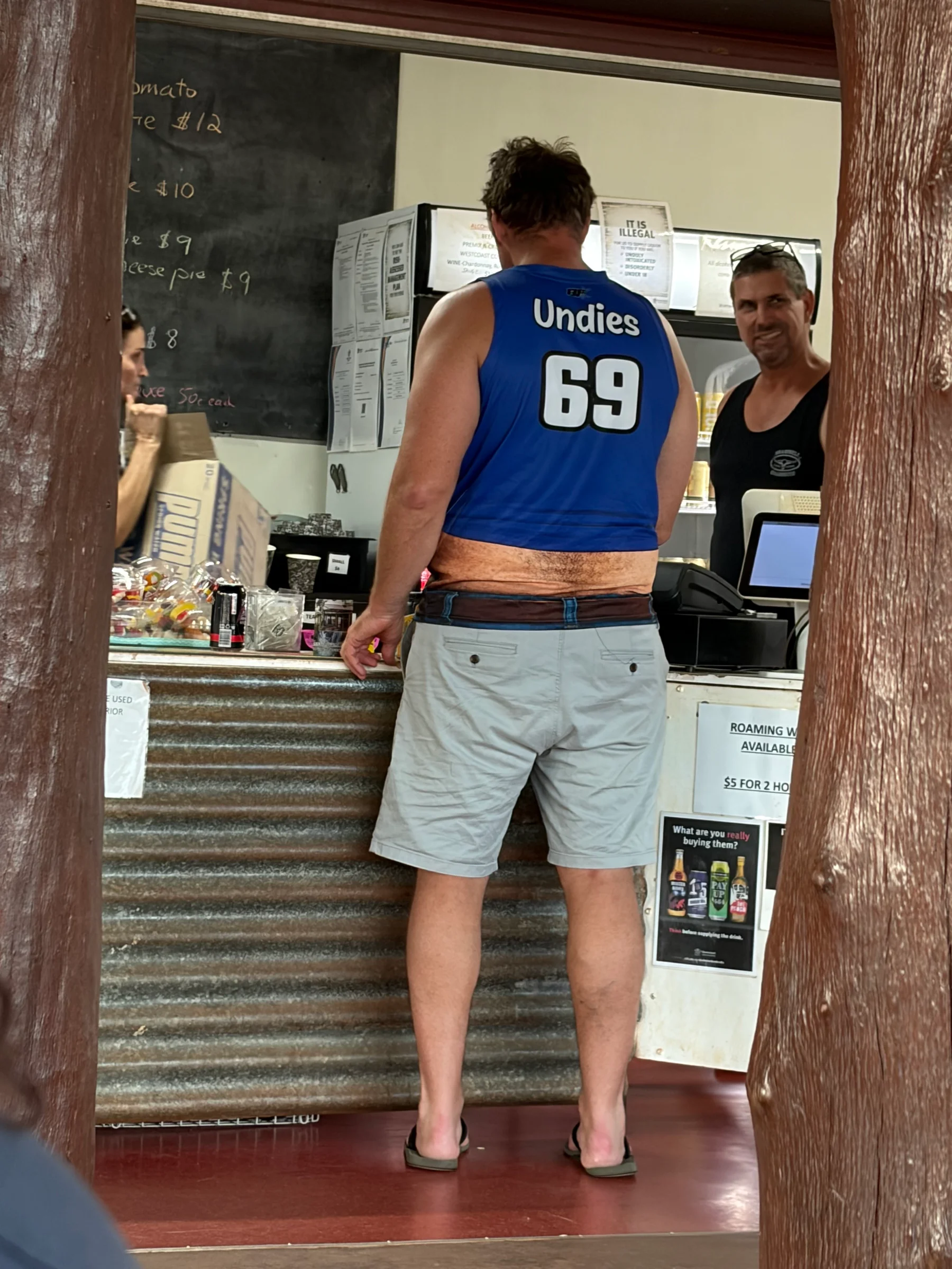 One of the birthday dirt bikers at the bar counter wearing a blue jersey printed with Undies 69