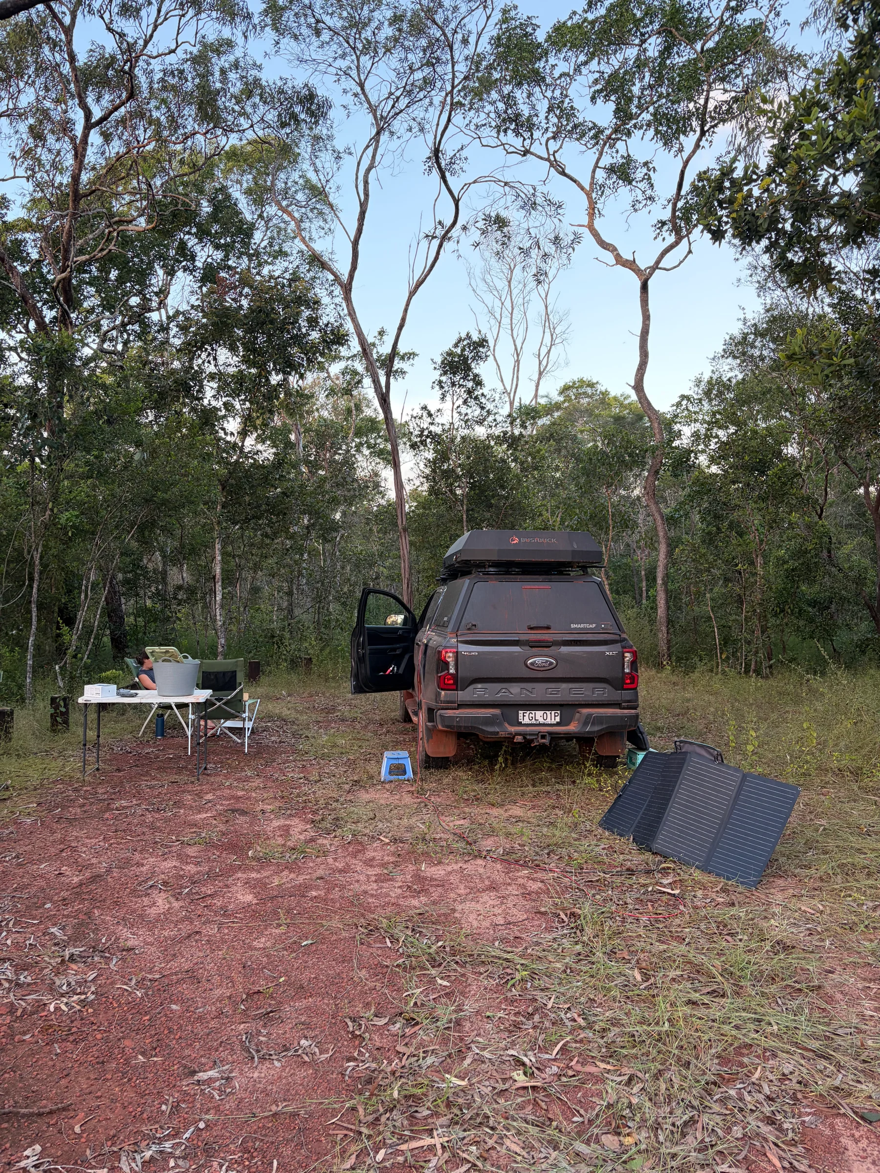 Roger parked at the Elliot Falls campsite with the camp table set up and a solar panel on the ground